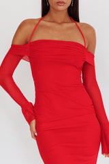 woman wearing a red bodycon dress with off-shoulder styling and long sheer sleeves