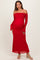 woman wearing a red off-the-shoulder maternity dress with long sleeves and a fitted silhouette, showing her baby bump