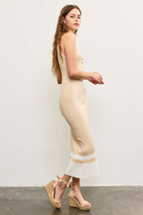 woman wearing a beige ribbed midi dress with buttons and a flared hem, paired with tan wedge sandals