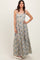woman wearing a floral print maxi dress with spaghetti straps and a tiered skirt