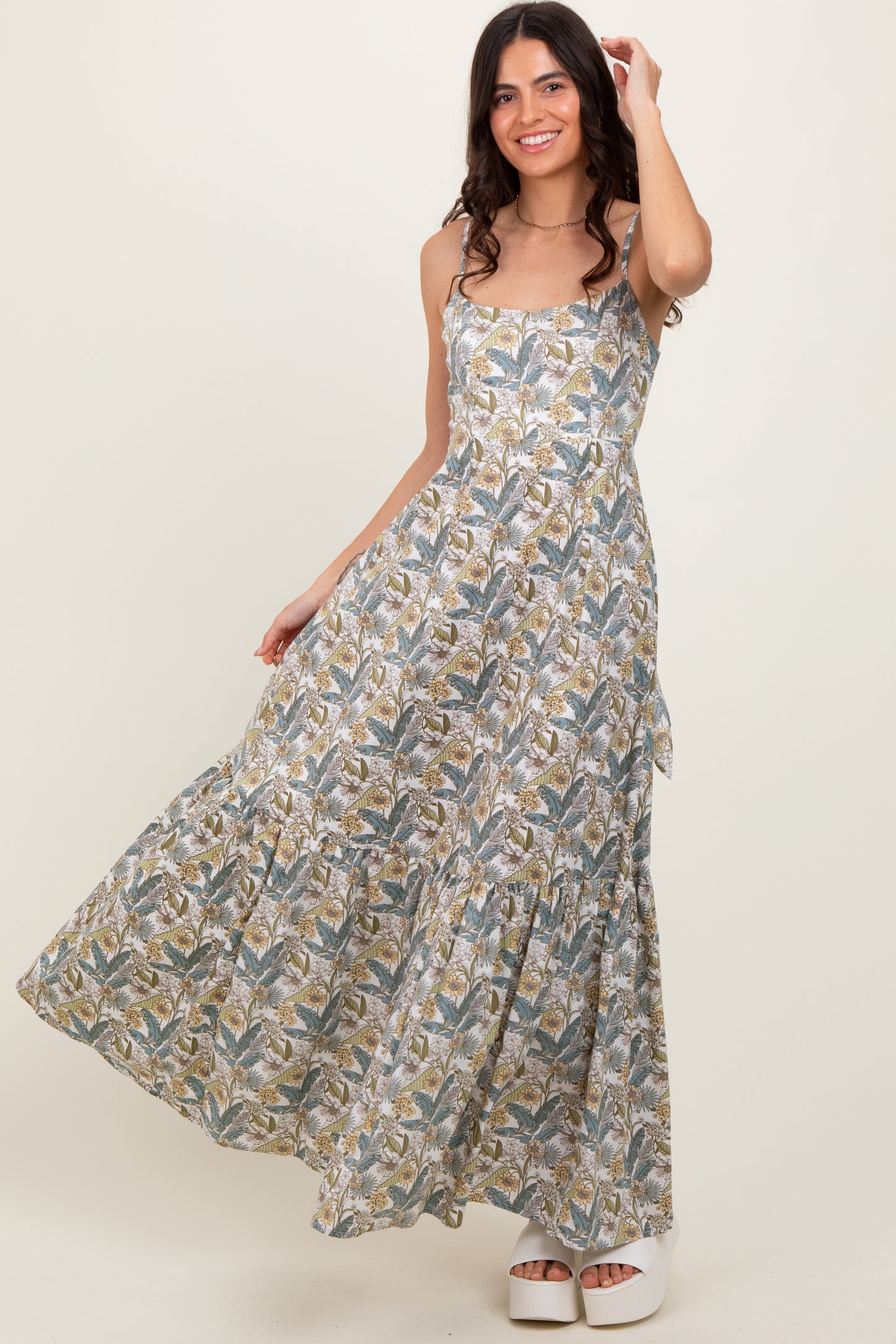 woman wearing a floral patterned maxi dress with a fitted bodice and tiered skirt