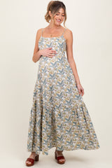 woman wearing a floral print maternity maxi dress with spaghetti straps and a baby bump visible