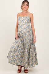woman wearing a floral patterned maxi maternity dress with adjustable straps and a baby bump visible