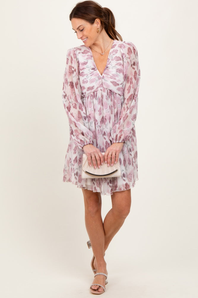 woman wearing a pink floral long sleeve dress with a v-neck and holding a small clutch purse