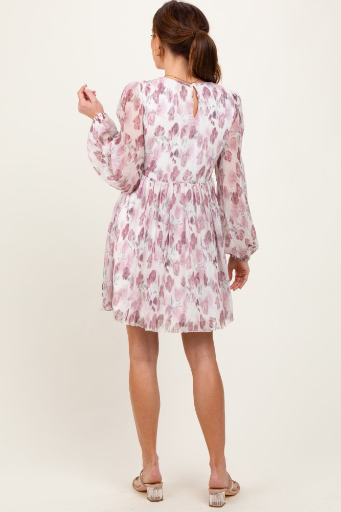 woman wearing a pink floral short dress with long sleeves and a keyhole back detail