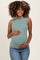 woman wearing a green sleeveless maternity top and holding her baby bump