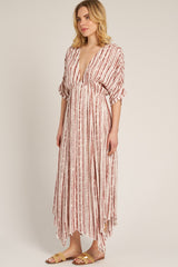 woman wearing a patterned maxi dress with a deep v-neckline and flutter sleeves, styled with tan sandals