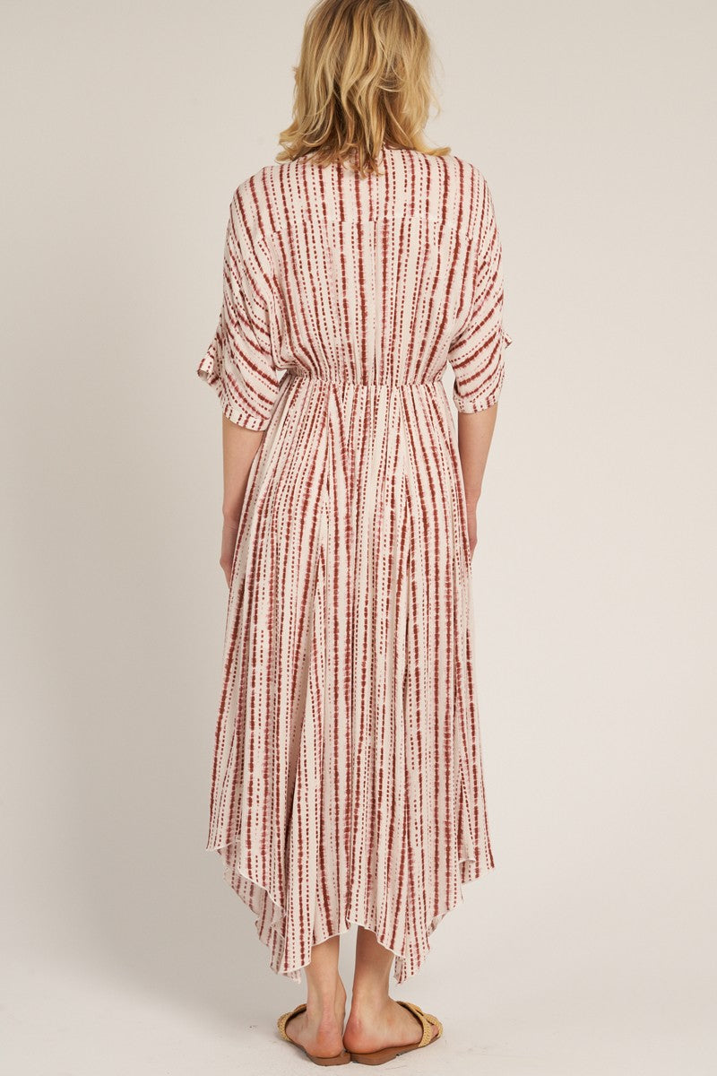 woman wearing a white and red striped maxi dress with a high-low hem and tied waist, shown from the back