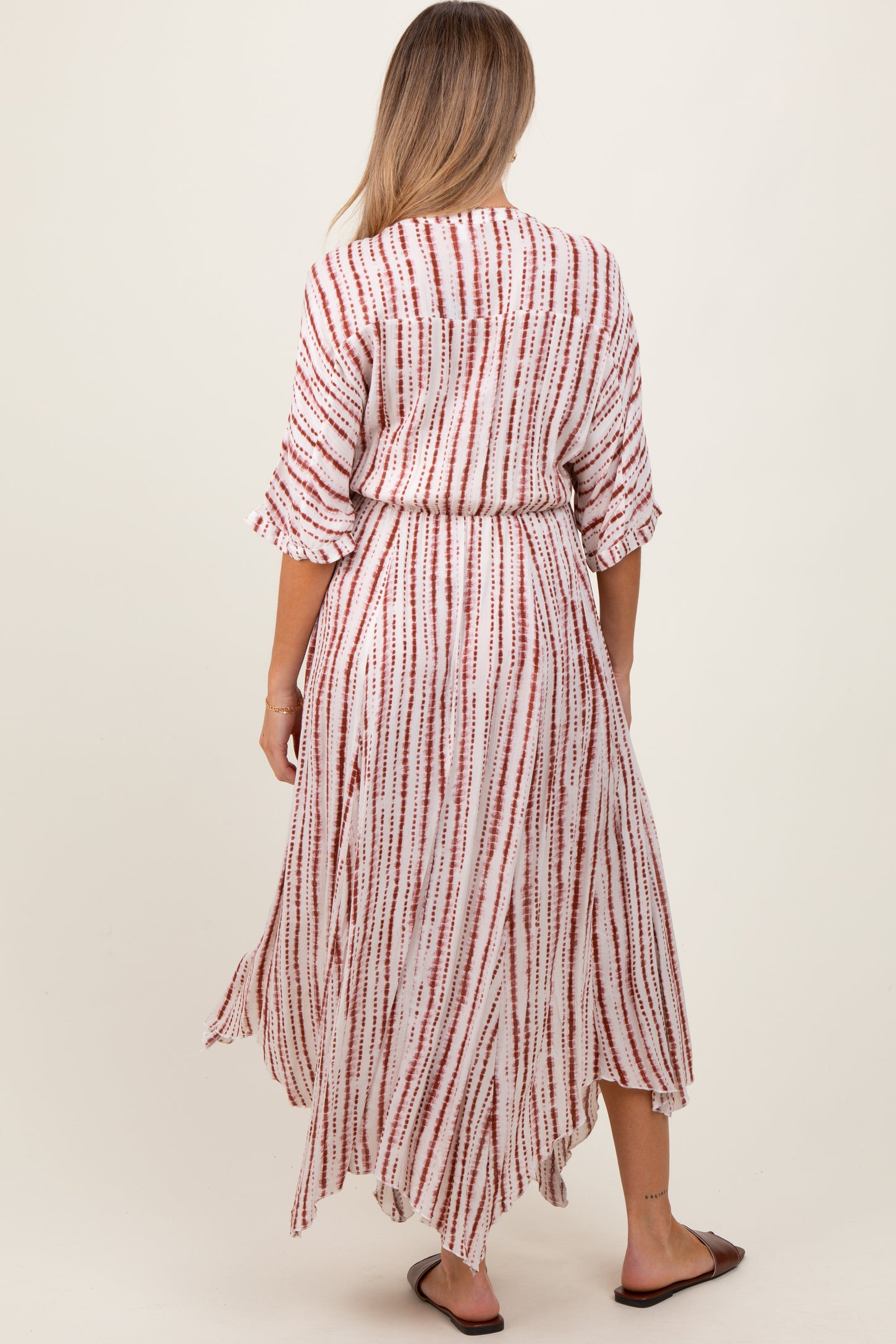 woman wearing a red and white striped maternity maxi dress with three-quarter sleeves and a tie waist, seen from the back