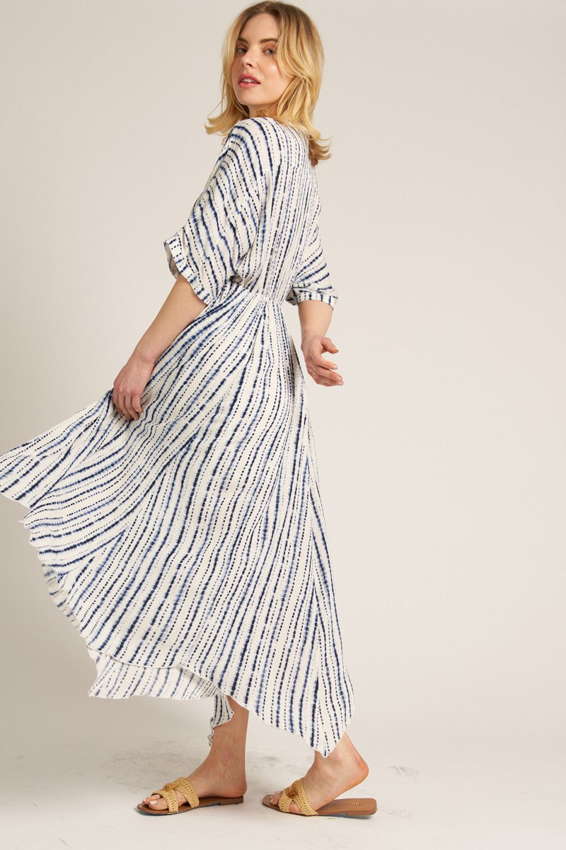 woman wearing a white and navy striped maxi dress with short sleeves and a flowing skirt