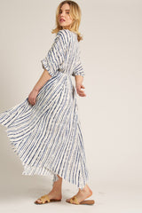 woman wearing a white and navy striped maxi dress with short sleeves and a flowing skirt
