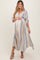 woman wearing a grey striped maternity dress with a deep v-neck and elbow-length sleeves, holding her baby bump