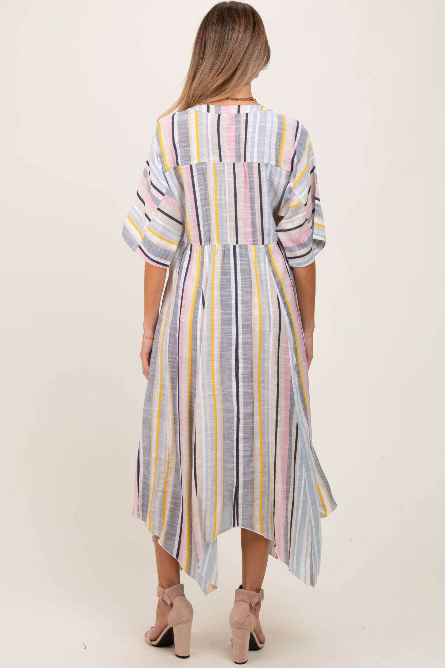 woman wearing a striped maternity dress with a high-low hem and three-quarter sleeves, seen from the back