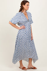 woman wearing a white and blue floral print maxi dress with short sleeves and a deep v-neckline