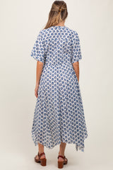 woman wearing a blue and white floral print maternity dress with short sleeves and an asymmetrical hemline