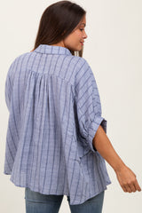 woman wearing a blue and white striped maternity blouse with roll-up sleeves and a loose fit, back view