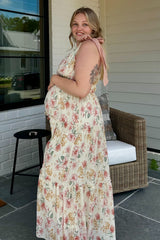 woman wearing a floral print maternity maxi dress with a tied shoulder detail and visible baby bump