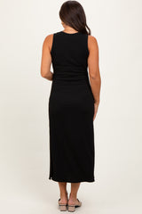 woman wearing a black sleeveless maternity maxi dress, showing a fitted silhouette and long length from the back