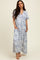 woman wearing a blue and white floral maxi dress with short sleeves and pockets