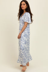 woman wearing a floral blue and white maxi dress with short flutter sleeves and a flowing silhouette