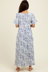 woman wearing a blue and white floral maxi dress with short sleeves, shown from the back