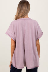 woman wearing a light purple oversized maternity top with short sleeves and a relaxed fit