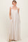 woman wearing a flowy cream maxi dress with adjustable straps and pockets