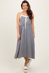 woman wearing a black and white gingham midi dress with adjustable straps and a drawstring detail