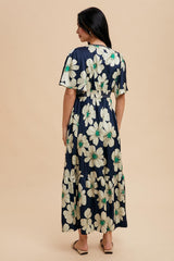 woman wearing a navy floral maxi dress with short flutter sleeves and a tiered skirt from the back