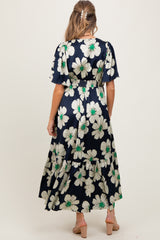 woman wearing a navy floral maternity dress with short sleeves and a tiered skirt, showing a baby bump from behind