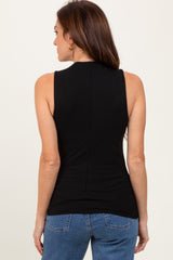 woman wearing a sleeveless black ribbed top with a high neckline, viewed from the back with blue jeans