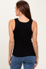 woman wearing a black ribbed tank top with a fitted silhouette and paired with blue jeans, viewed from the back