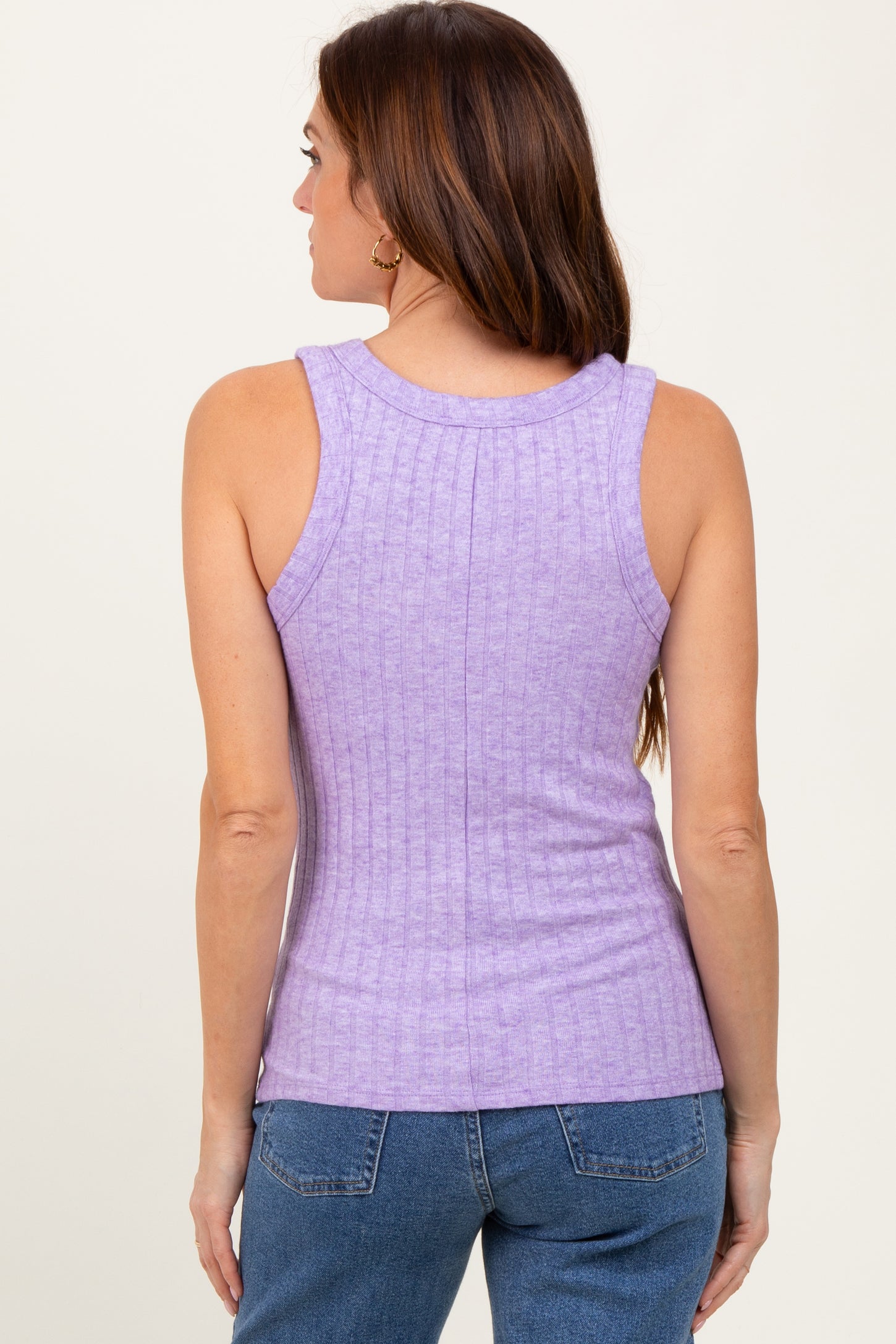 woman wearing a lavender ribbed sleeveless top, seen from the back, paired with blue denim jeans