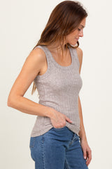 woman wearing a light brown ribbed tank top with a scoop neckline and side slits, paired with blue jeans