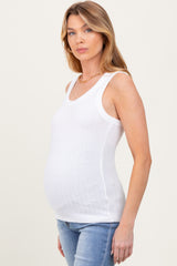 woman wearing a white ribbed maternity tank top highlighting her baby bump and paired with blue jeans