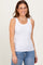 woman wearing a white ribbed tank top with a scoop neckline and light blue jeans