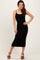 woman wearing a black ribbed midi dress with spaghetti straps and brown heeled sandals