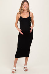 woman wearing a black ribbed maternity dress with thin straps and a baby bump visible
