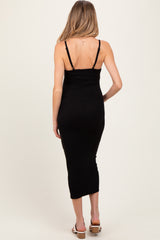 woman wearing a black ribbed maternity dress with adjustable straps and a fitted silhouette, showing her back