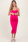 woman wearing a hot pink ribbed maternity dress with spaghetti straps and a visible baby bump