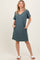 woman wearing a teal short sleeve v-neck dress with side pockets and relaxed fit