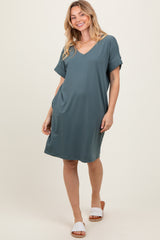 woman wearing a teal short sleeve v-neck dress with a relaxed fit and side pockets