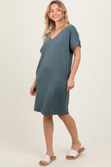 woman wearing a teal short sleeve v-neck dress and white slide sandals