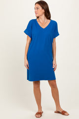 woman wearing a vibrant blue short sleeve v-neck dress with rolled sleeves and relaxed fit