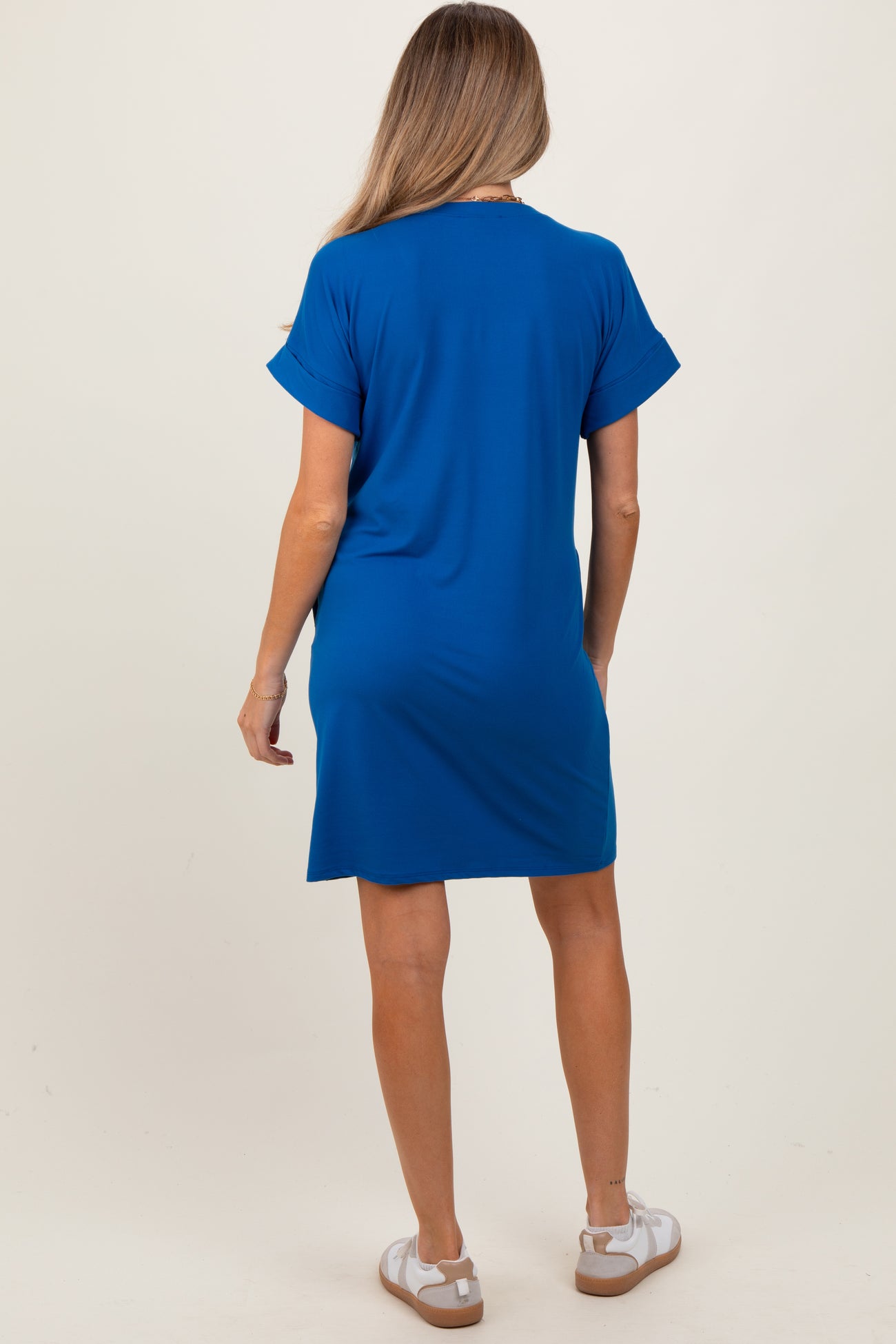 woman wearing a blue short sleeve maternity dress, showing the back view with a relaxed fit