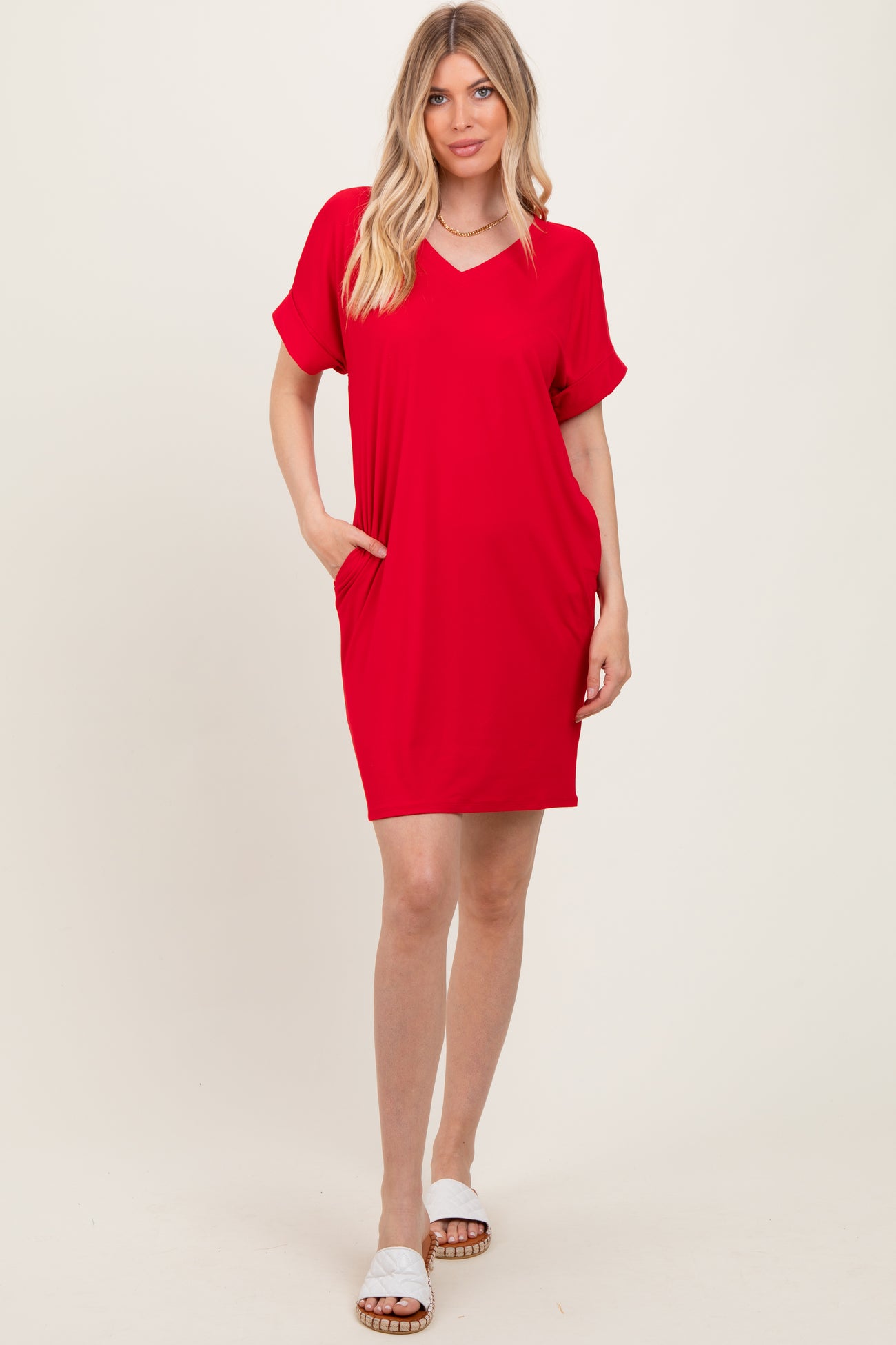 woman wearing a red short sleeve v-neck dress with side pockets and a relaxed fit