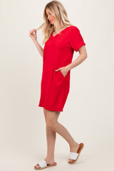 woman wearing a red short sleeve v-neck dress with side pockets and a relaxed fit