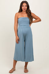 woman wearing a light blue strapless maternity jumpsuit with wide-leg pants and a relaxed fit