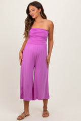 woman wearing a pink strapless maternity jumpsuit with flowy wide-leg bottoms and a fitted bodice