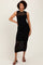 woman wearing a black sleeveless knitted midi dress with a crochet design and side slit